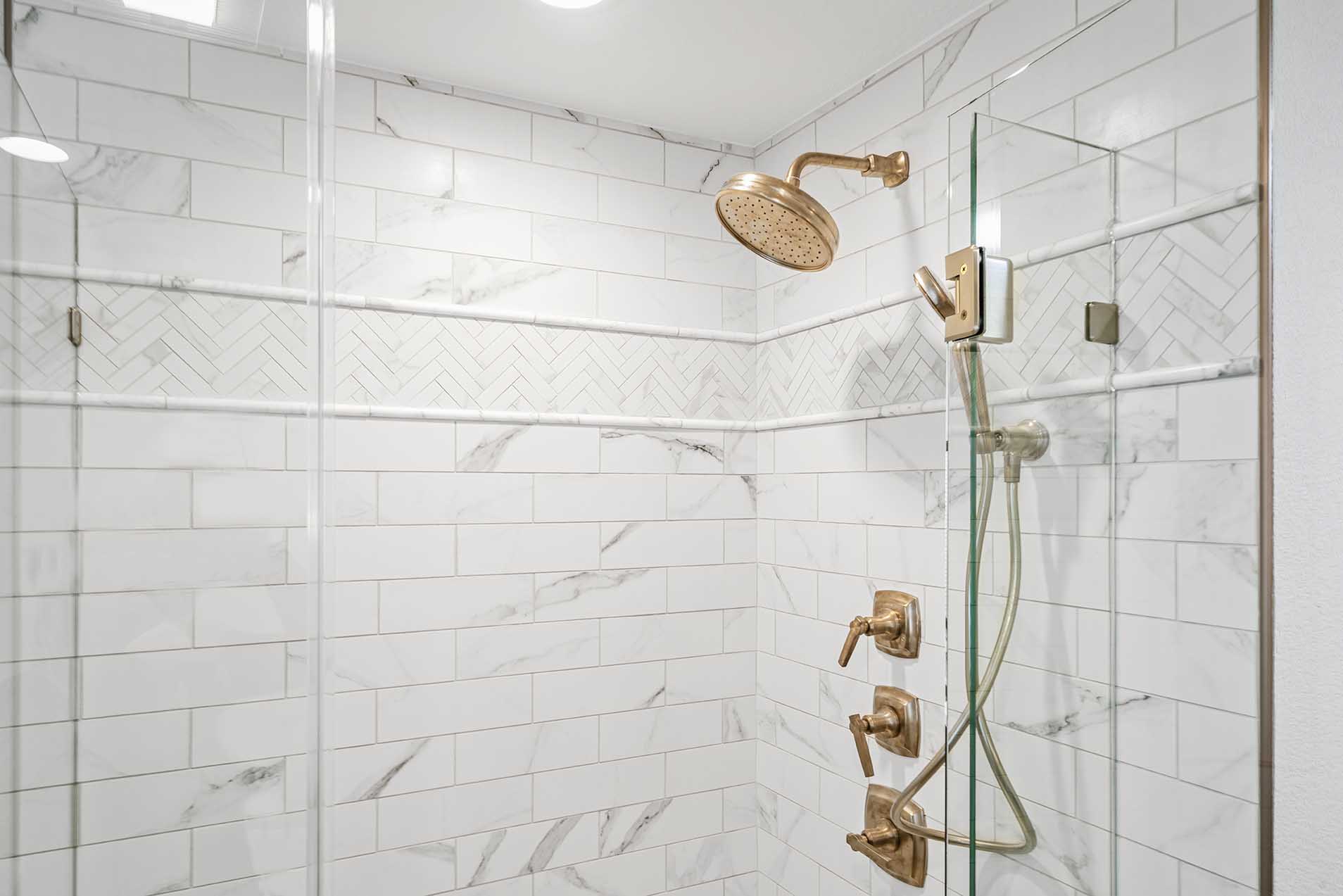 Remodeled shower corner with glass and bronze hardware