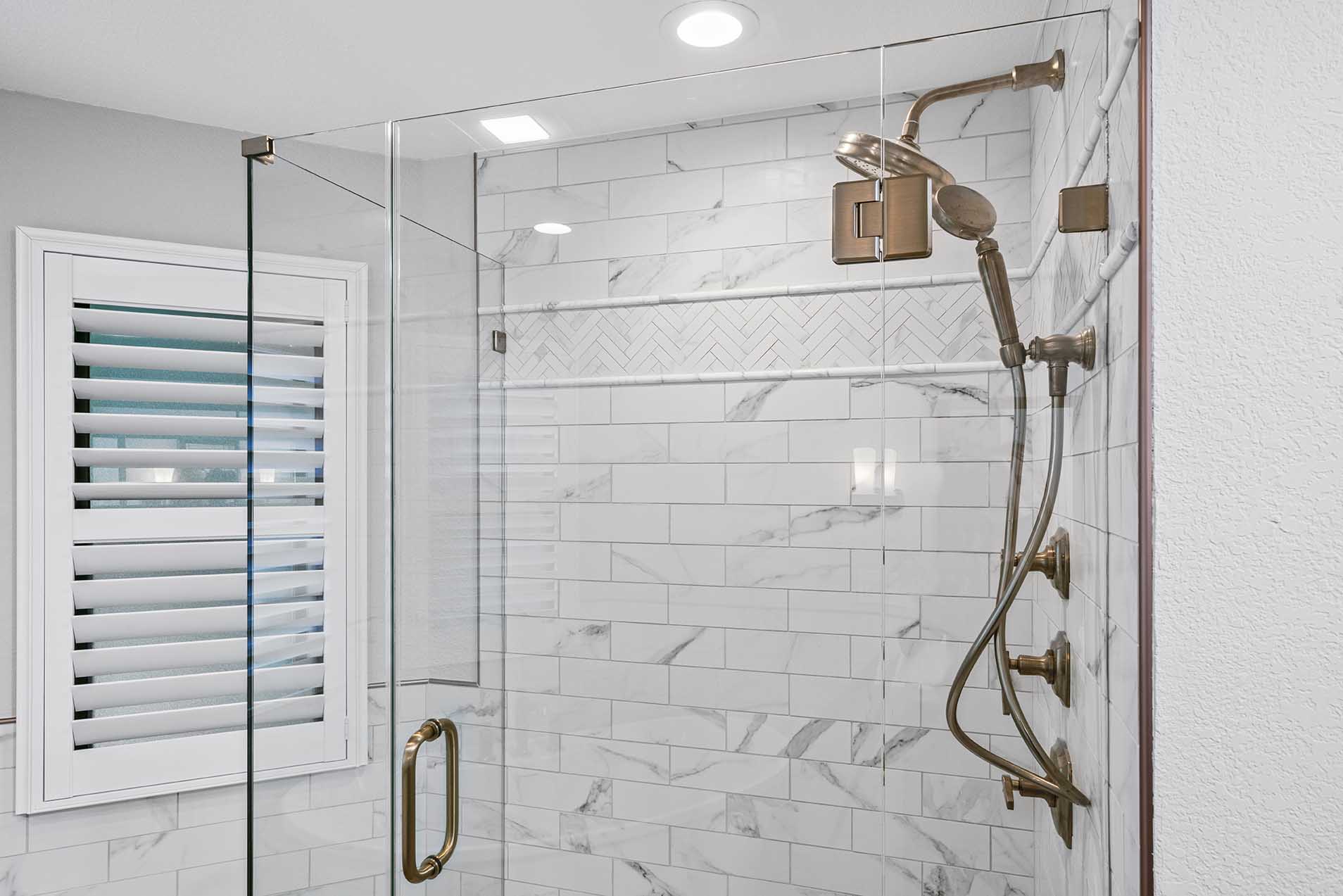 Shower with bronze fixtures and glass enclosure