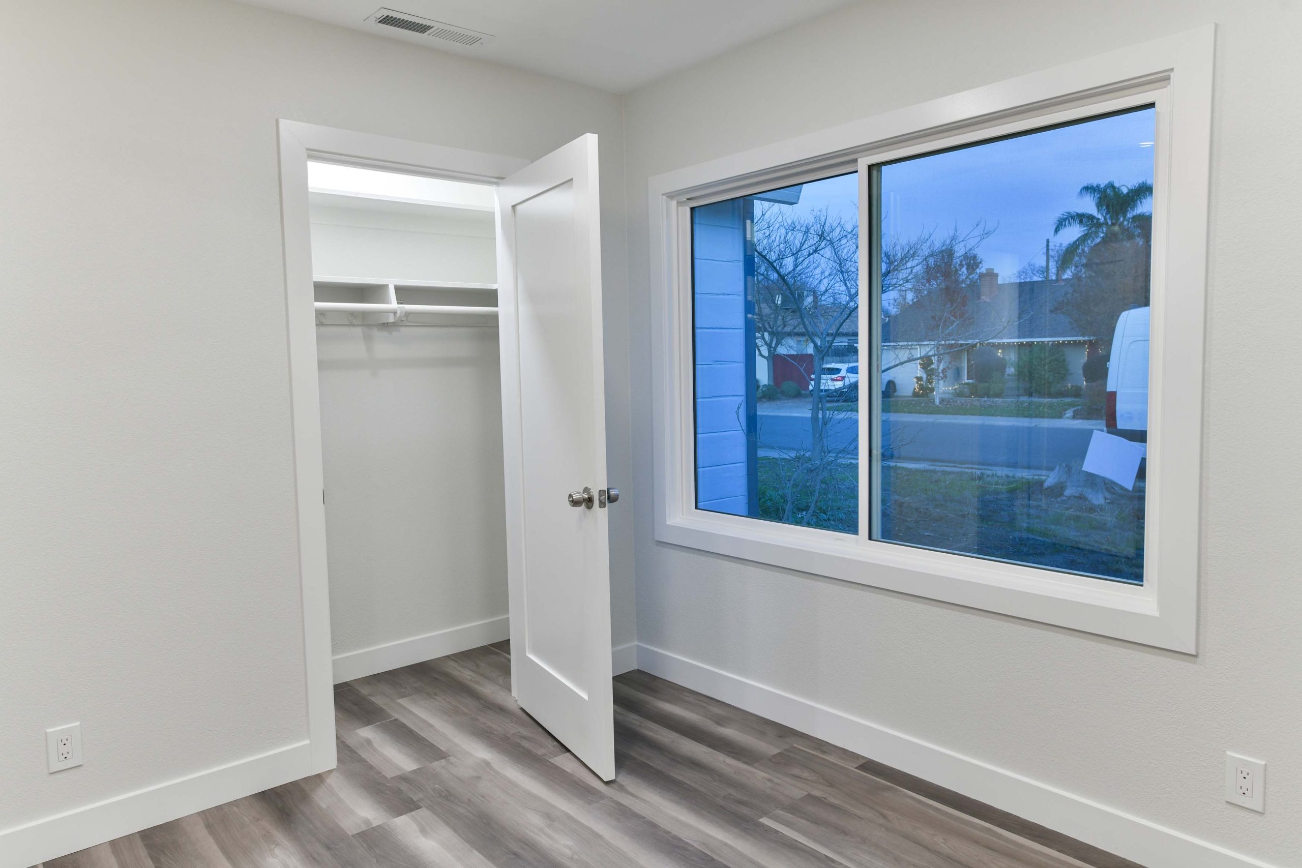 Updated bedroom with new flooring, fresh drywall and paint, upgraded window trim, and a refreshed closet for a clean, modern look.