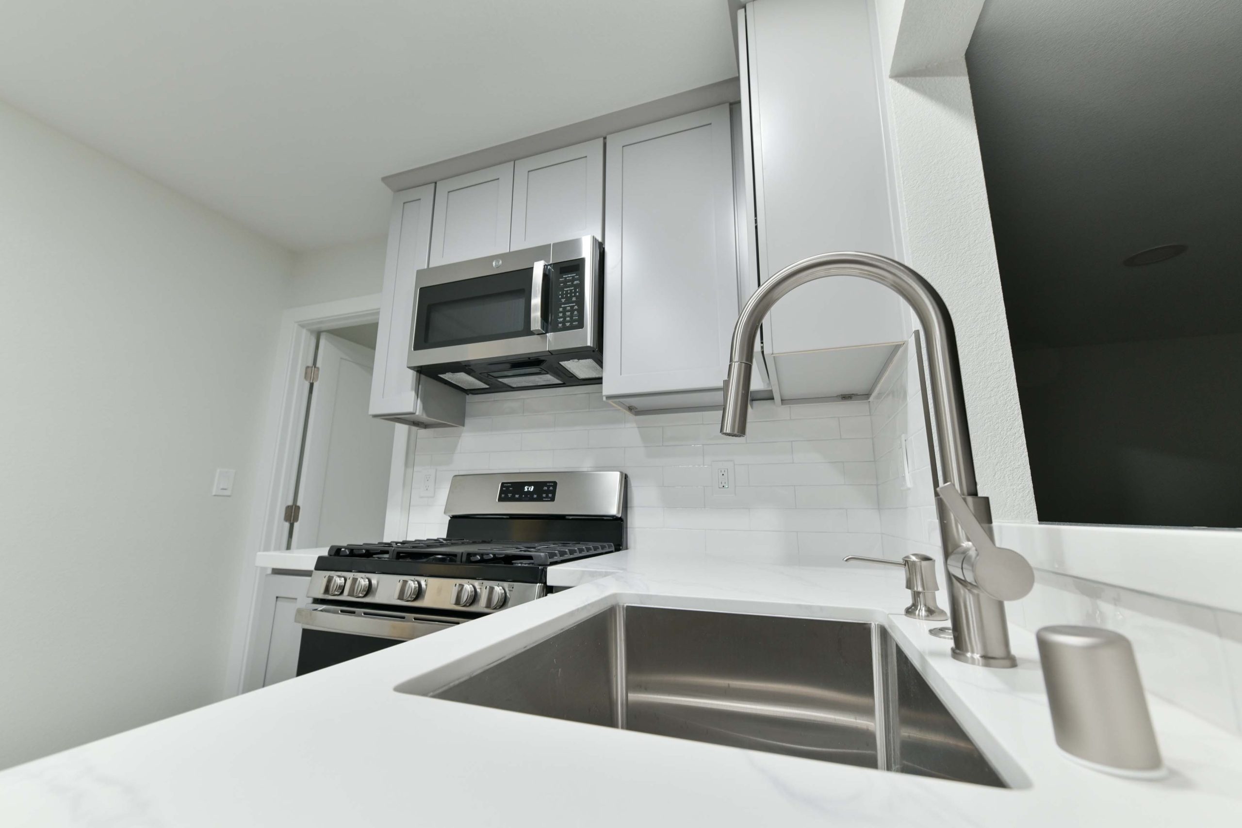 Close-up of modern kitchen faucet and deep stainless steel sink, combining durability and clean design for everyday use.