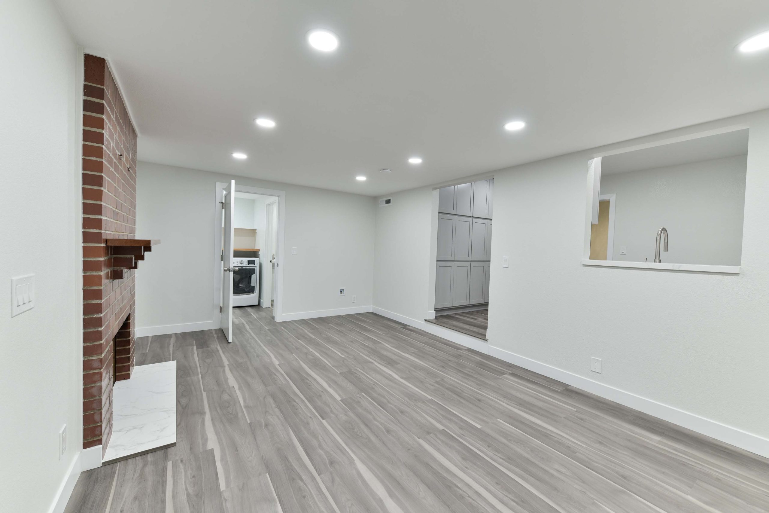 Open living space with updated flooring, recessed ceiling lights, smooth wall finishes, and improved flow between rooms.