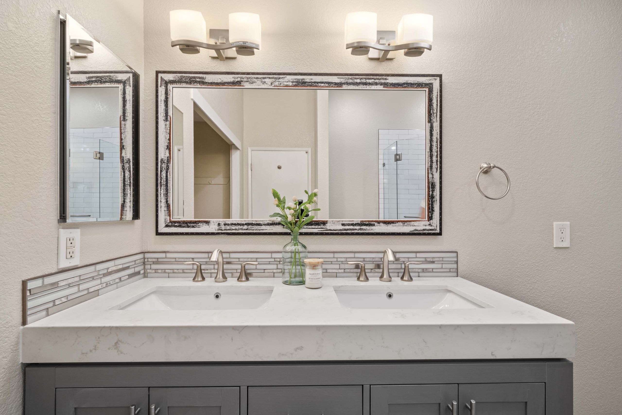 Double-sink vanity with quartz countertop and wall-mounted lighting in Roseville, CA 95678