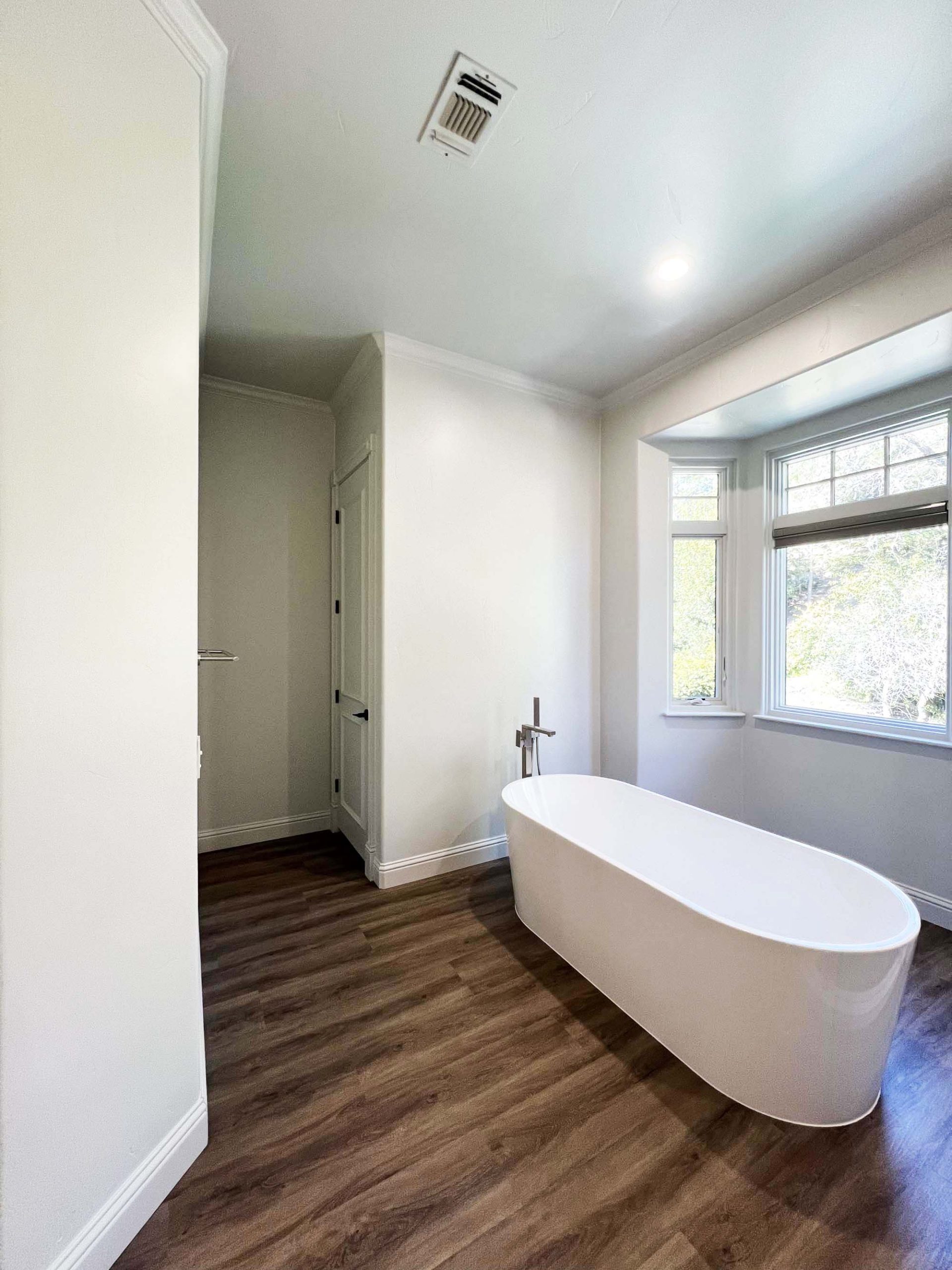 Freestanding bathtub positioned near natural light in a master bathroom remodel in Granite Bay, CA 95746