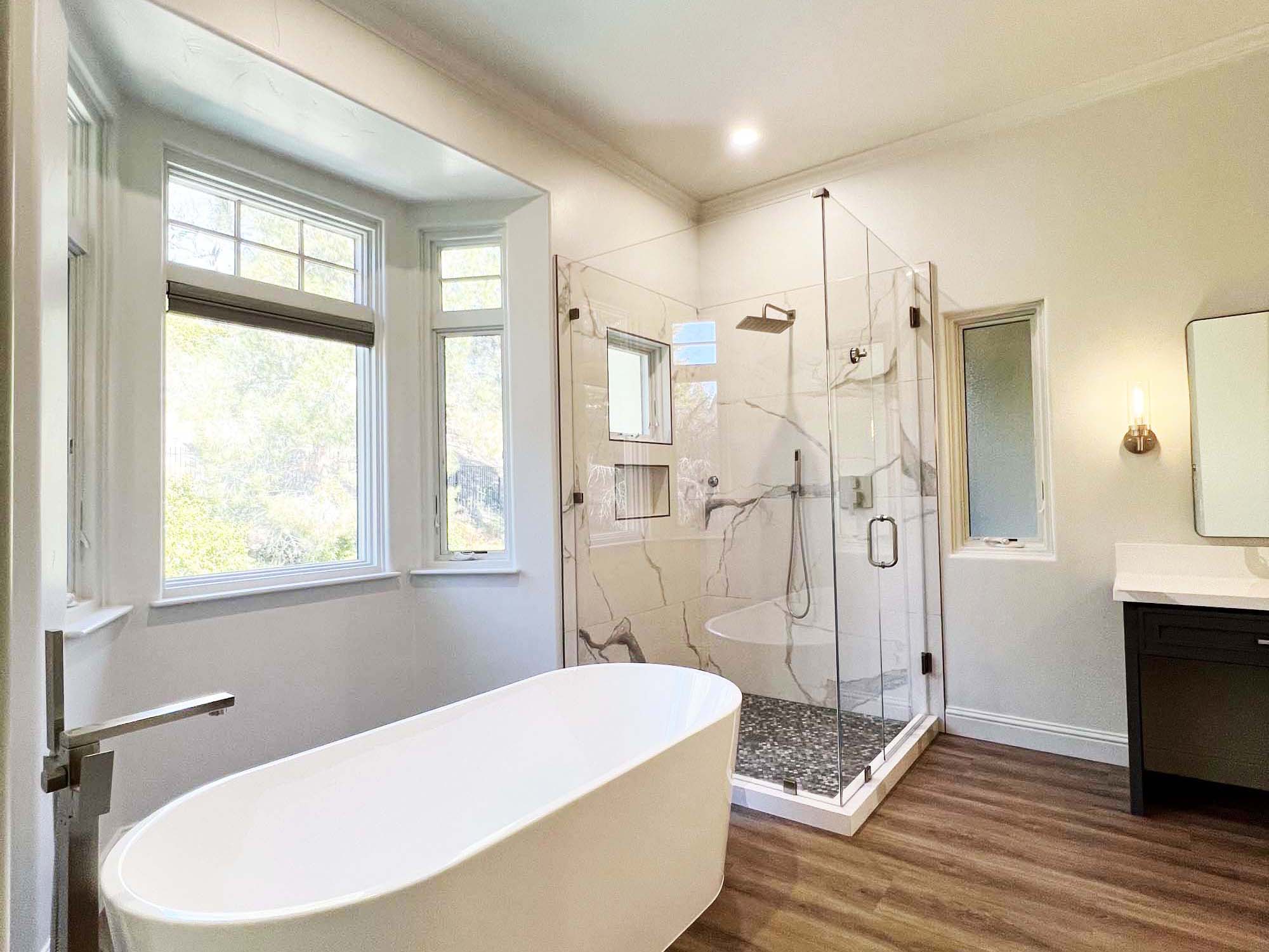 Freestanding tub and glass-enclosed walk-in shower in a modern master bathroom remodel in Granite Bay, CA 95746