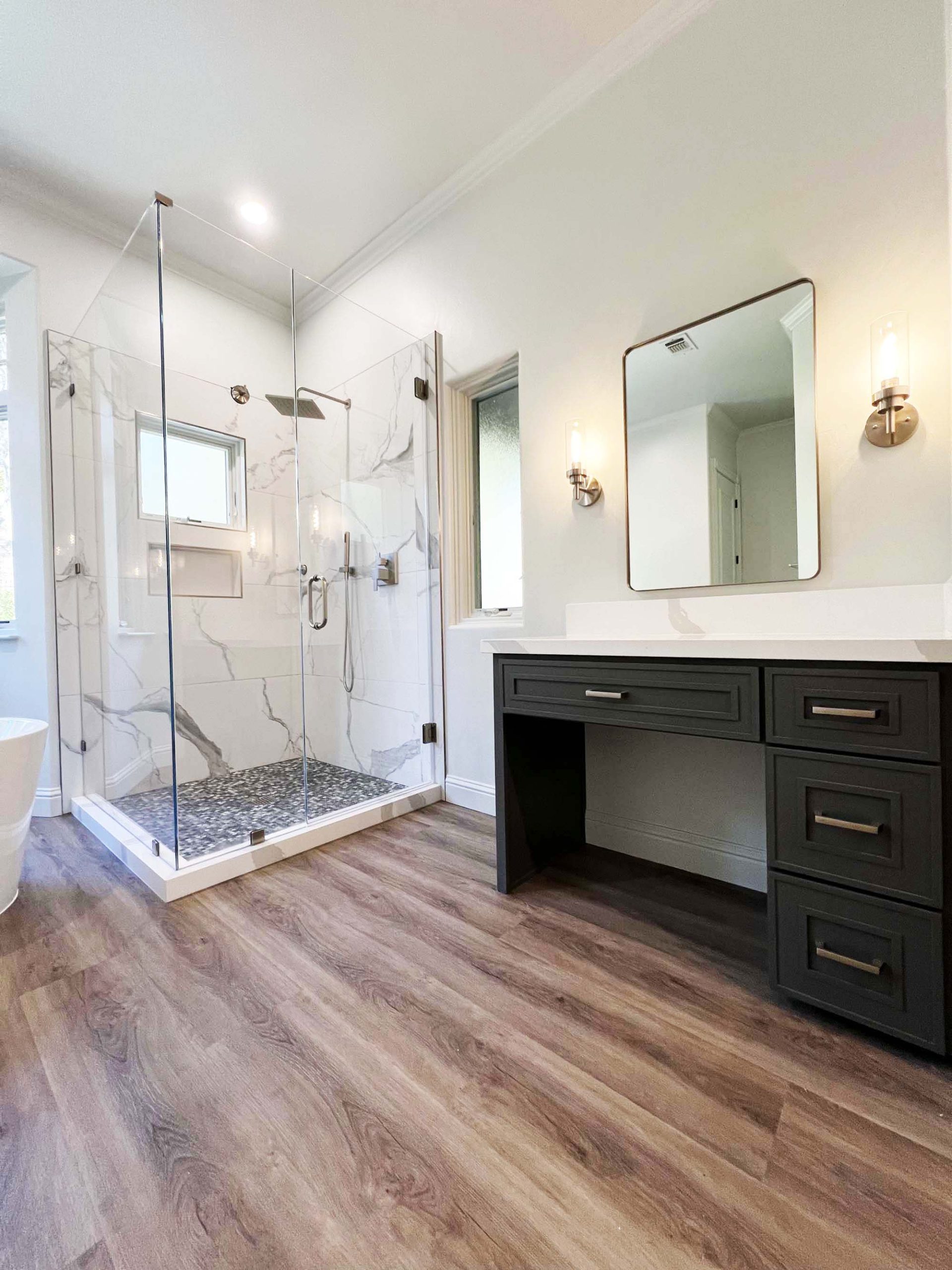 Glass-enclosed walk-in shower with large-format tile and adjacent makeup vanity in Granite Bay, CA 95746