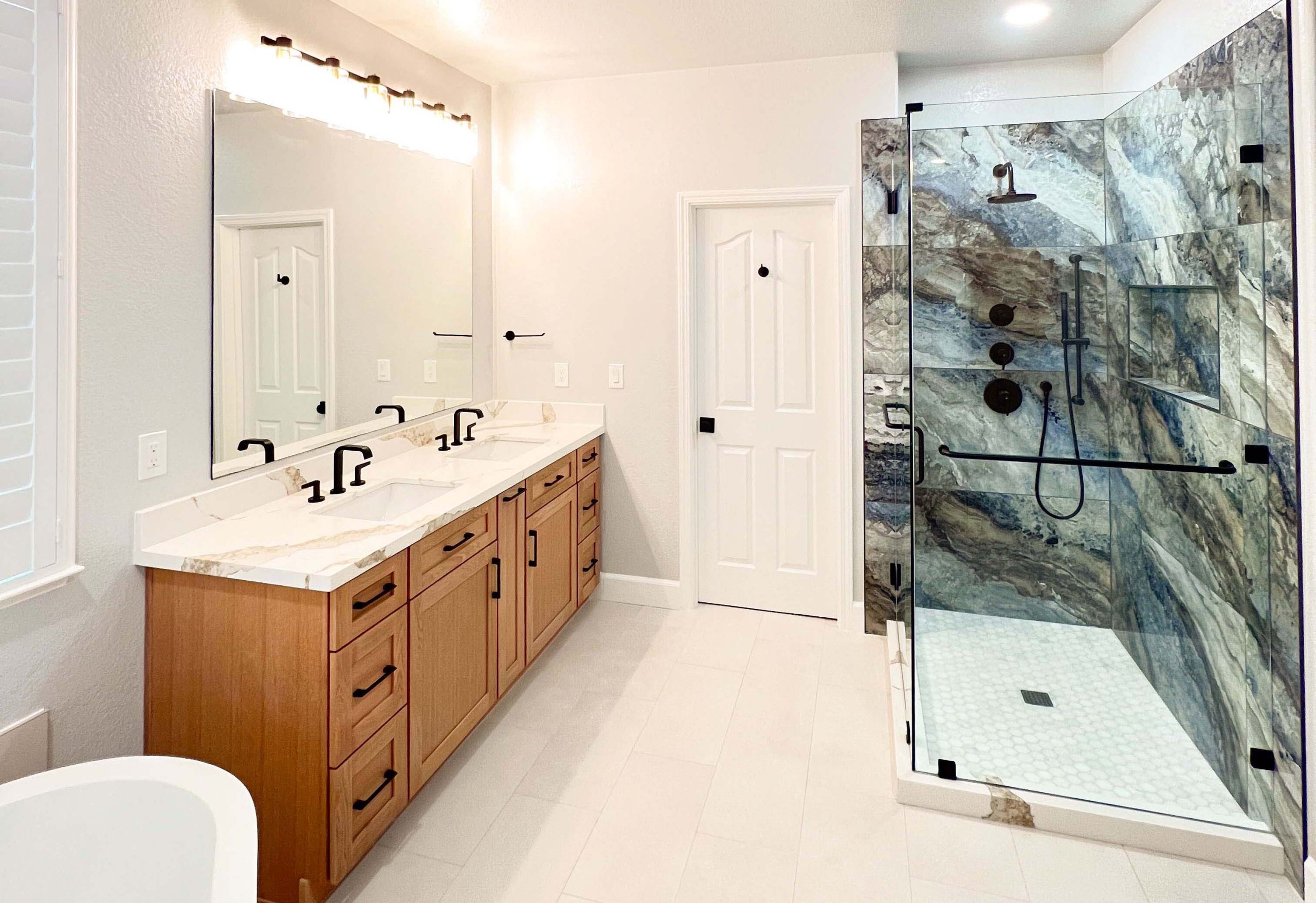 Second-floor bathroom remodel in Roseville, CA featuring a custom double-sink vanity and expanded walk-in shower with glass enclosure.