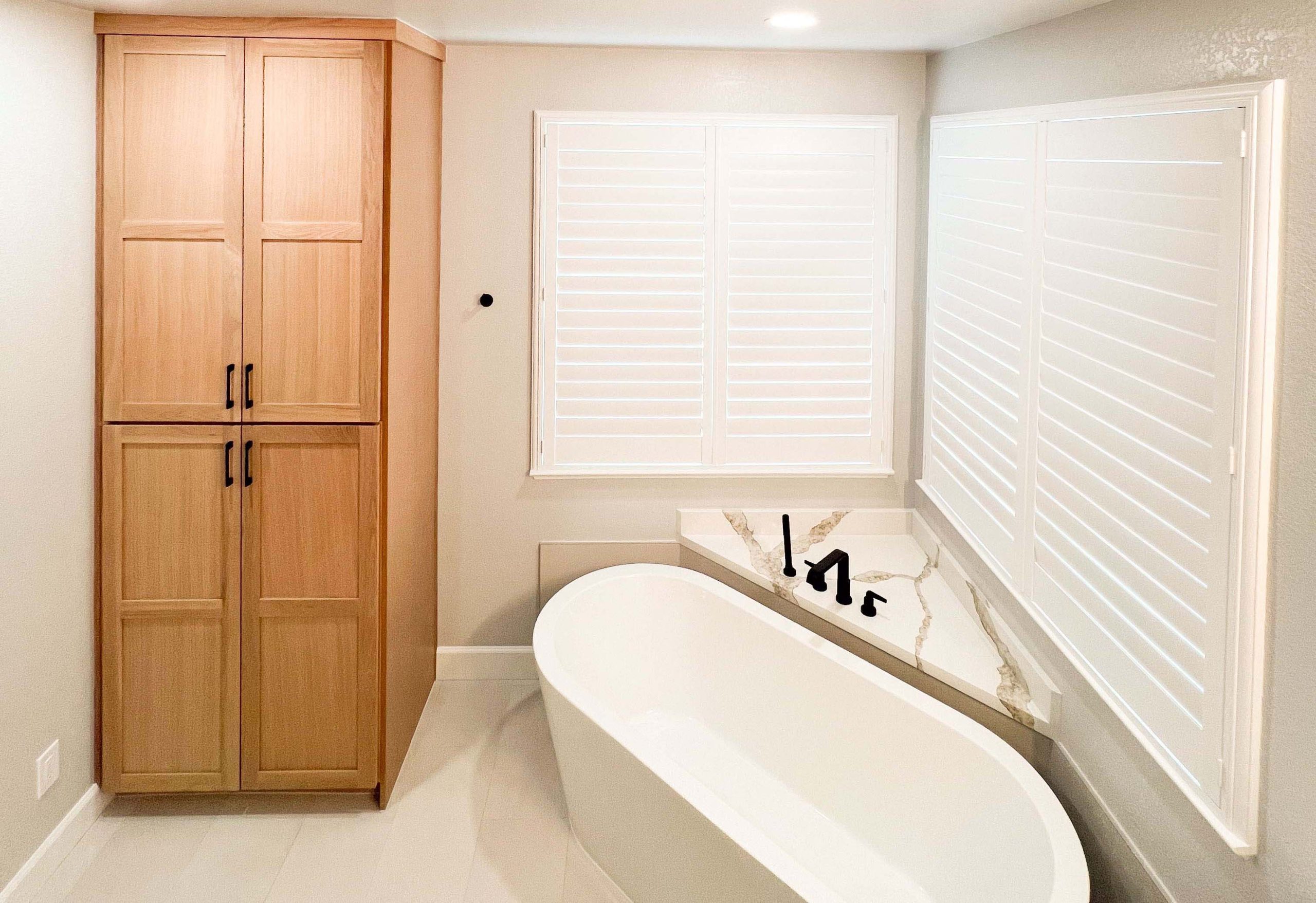 Custom pantry-style cabinets added next to a freestanding tub to maximize storage in this Roseville bathroom renovation.