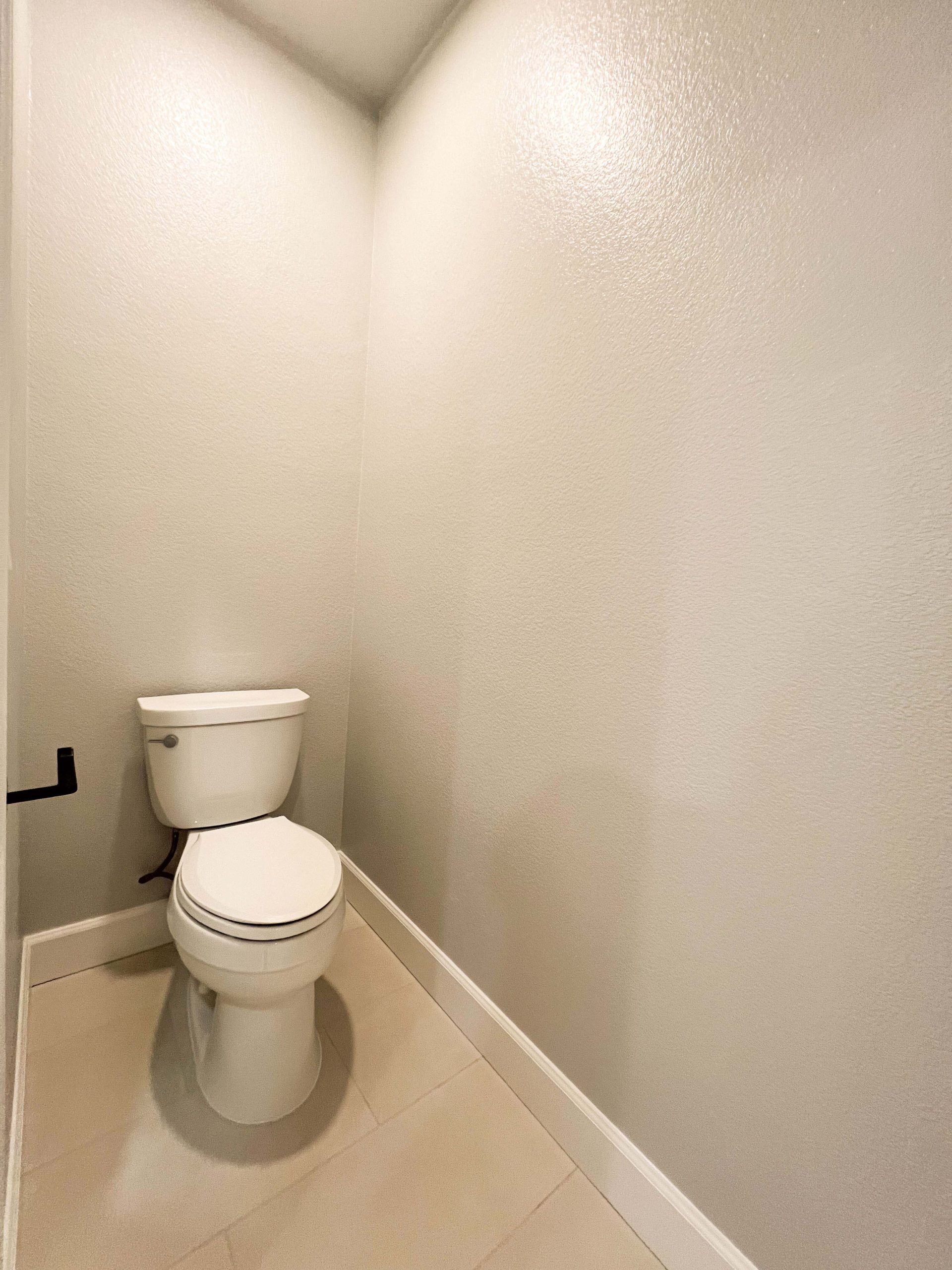 Private toilet room finished with new flooring, smooth drywall, and updated fixtures during a Roseville, CA bathroom renovation.