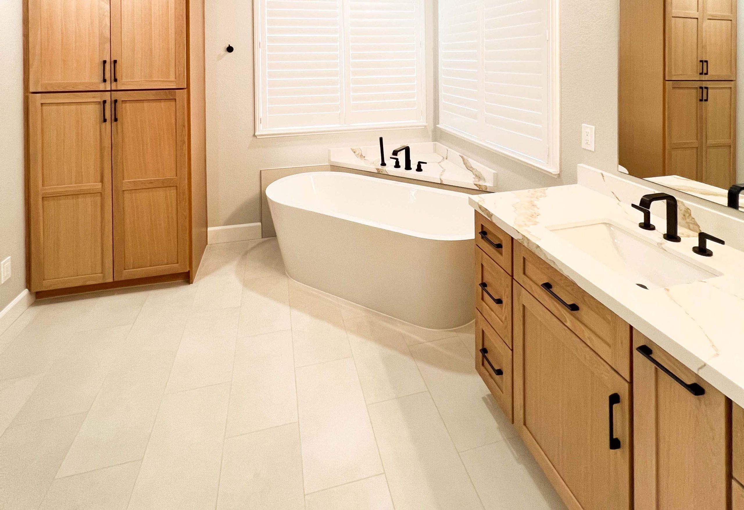 Master bathroom remodel in Roseville, CA with an open layout, freestanding tub, quartz countertops, and custom wood cabinetry.