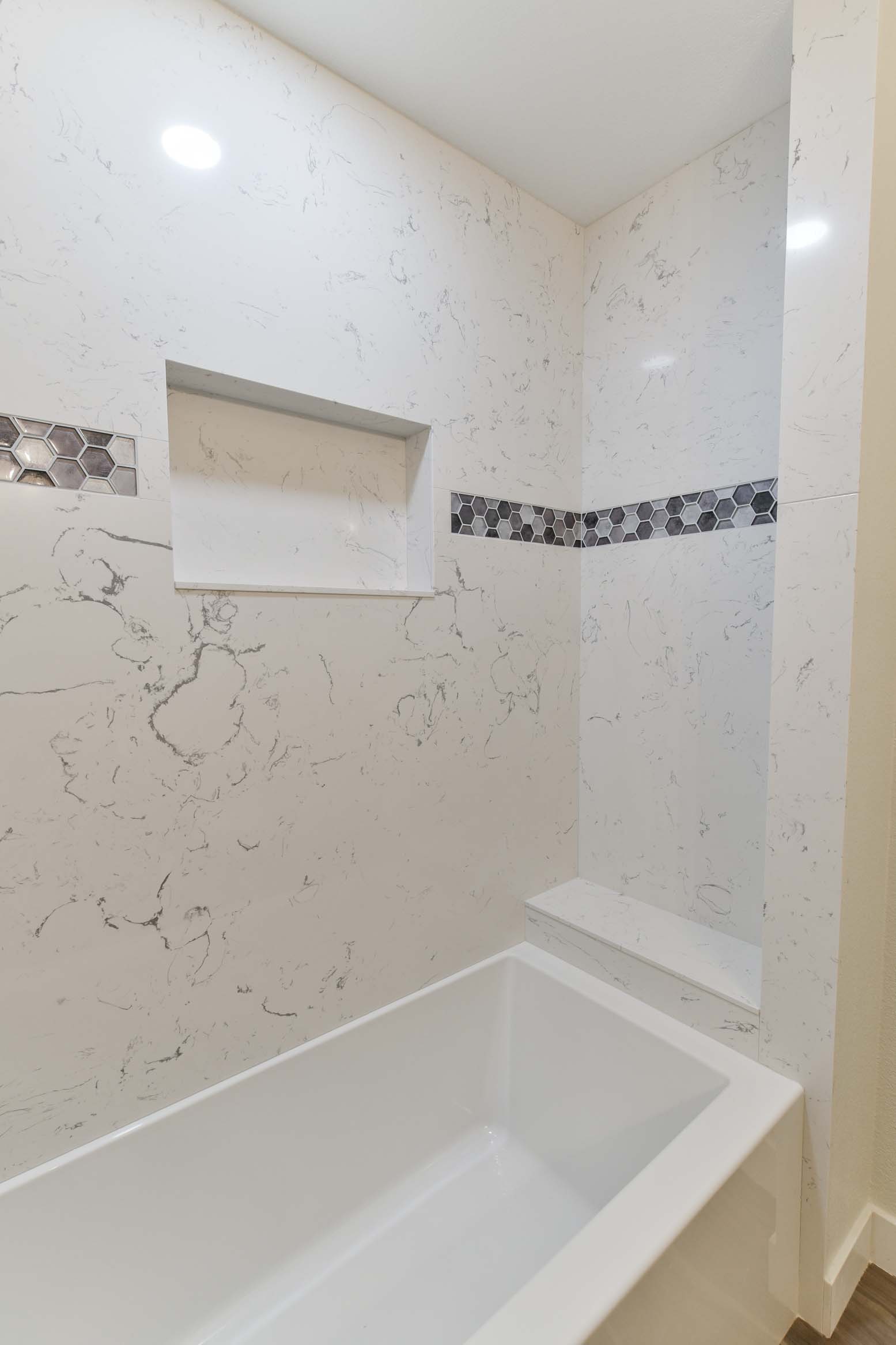 Clean-lined tub installation with integrated bench and tile surround.