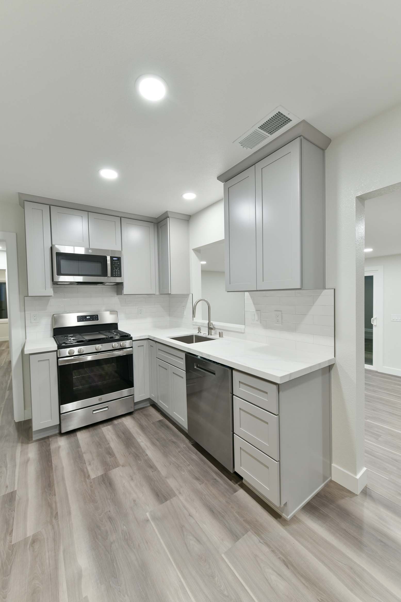 Clean, modern kitchen with stainless steel appliances and recessed lighting.