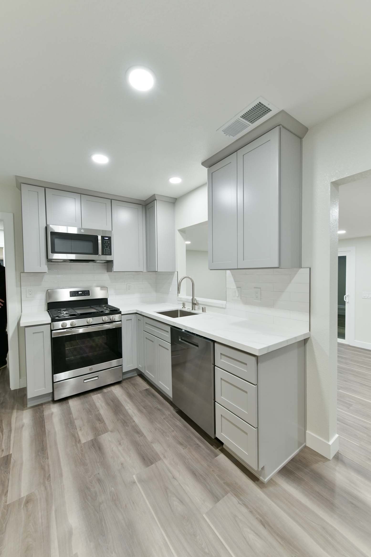 L-shaped kitchen layout with subway tile backsplash and functional workspace.