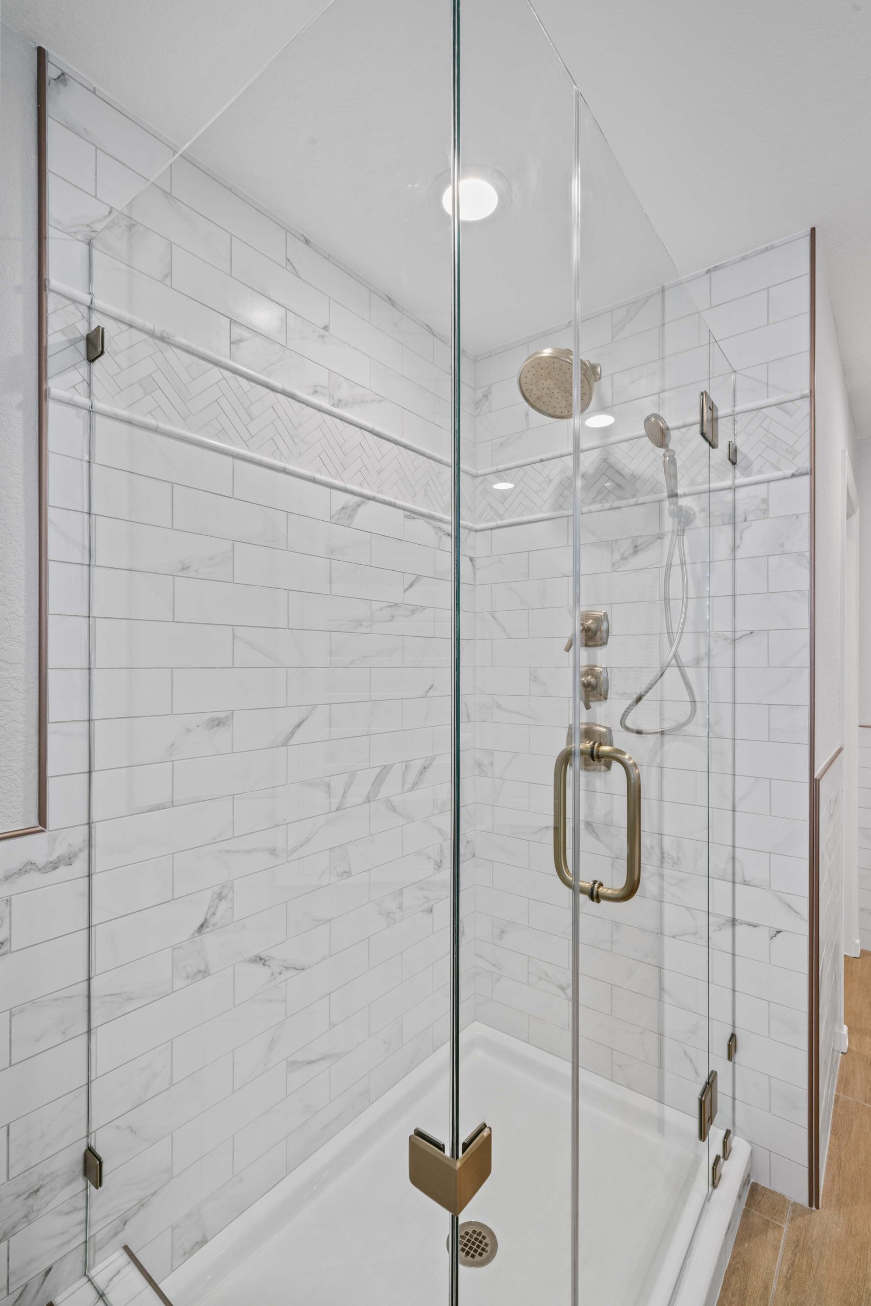 Frameless glass shower enclosure with premium bronze hinges and handle, part of a modern master bathroom renovation completed in Sacramento, CA 95825.