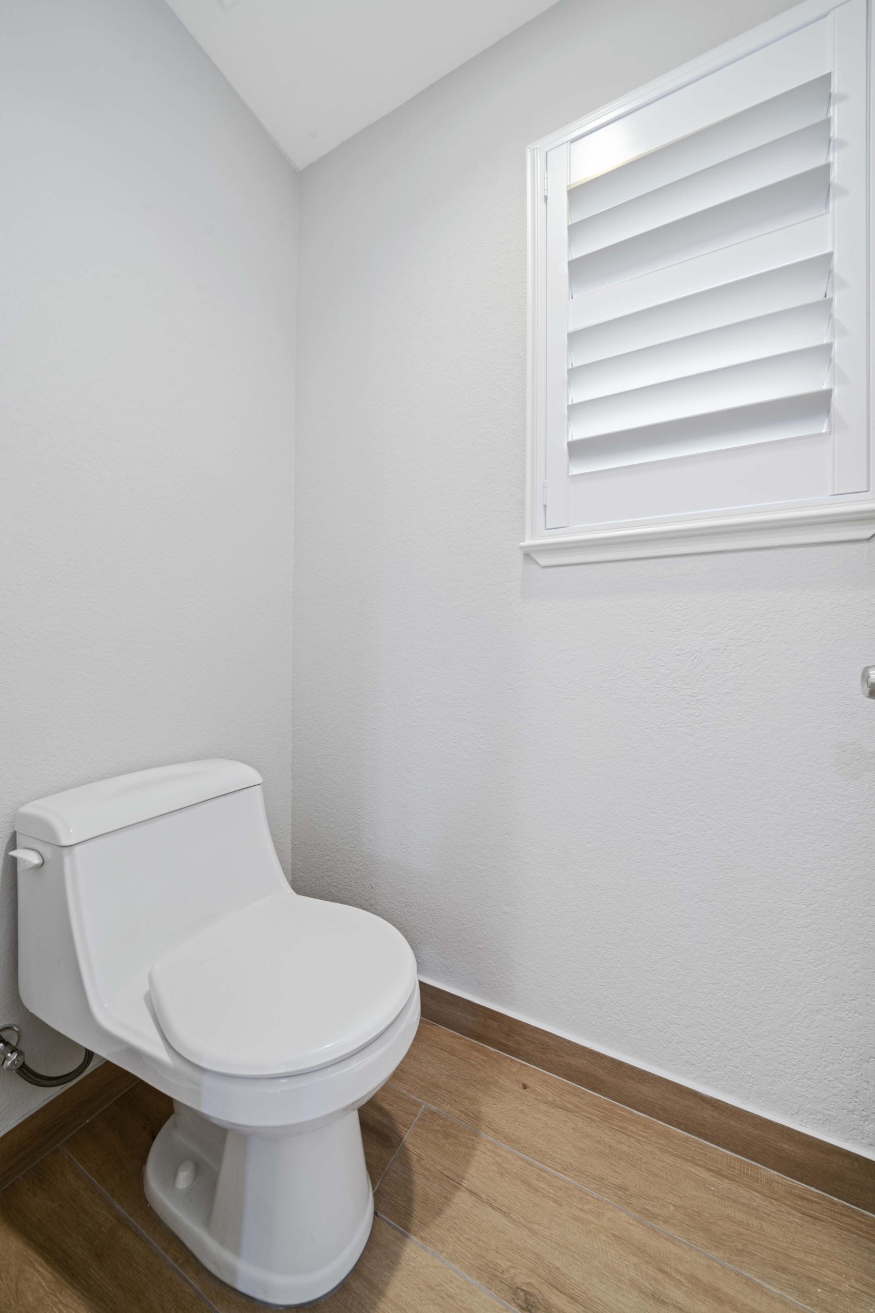 Updated bathroom layout in Sacramento, CA 95825 with new toilet placement, wood-look vinyl plank flooring, and smooth wall finishes for durability and easy maintenance.