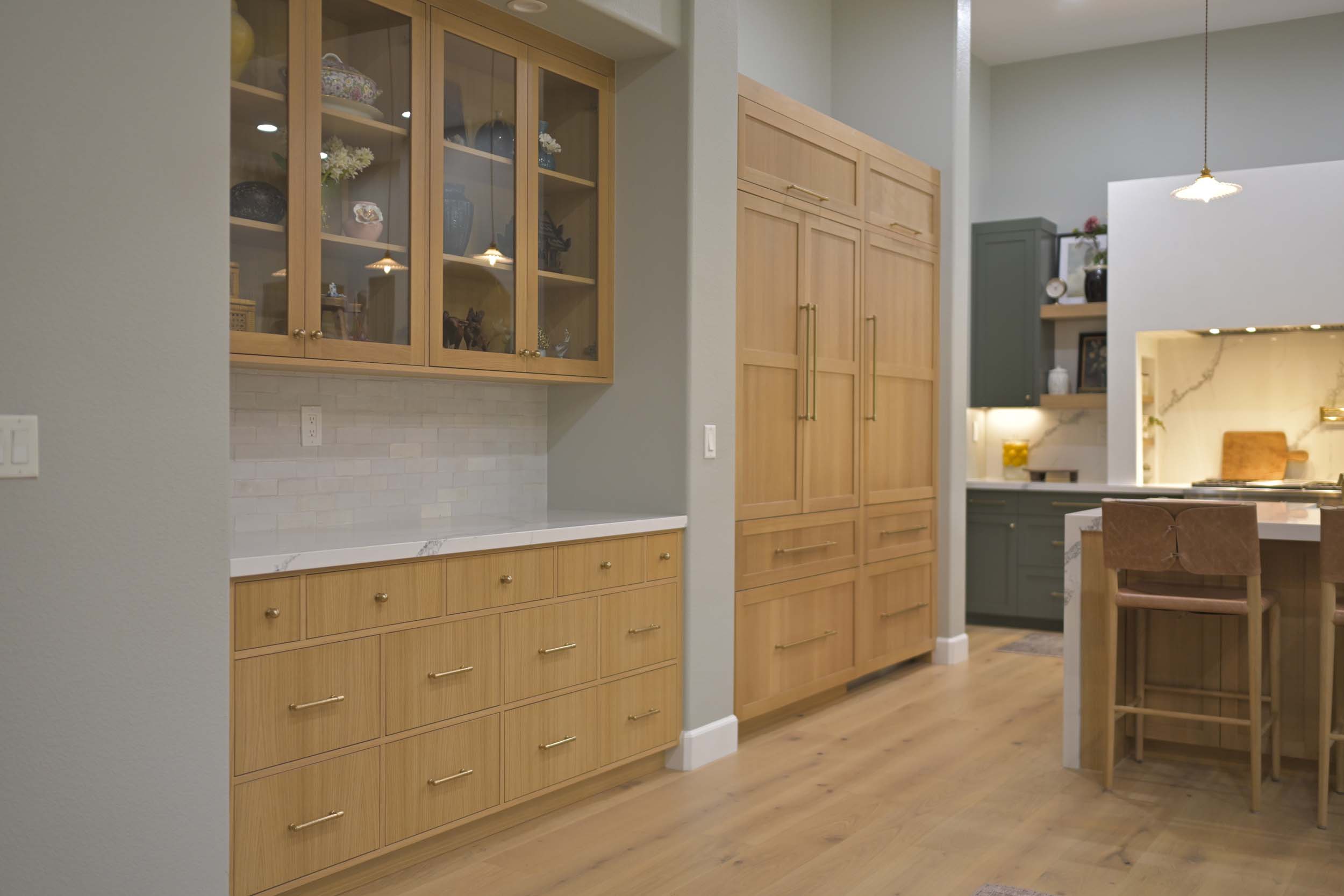 Kitchen remodel in Elk Grove, CA 95758 with glass front cabinets, pantry storage, and warm custom wood finishes.