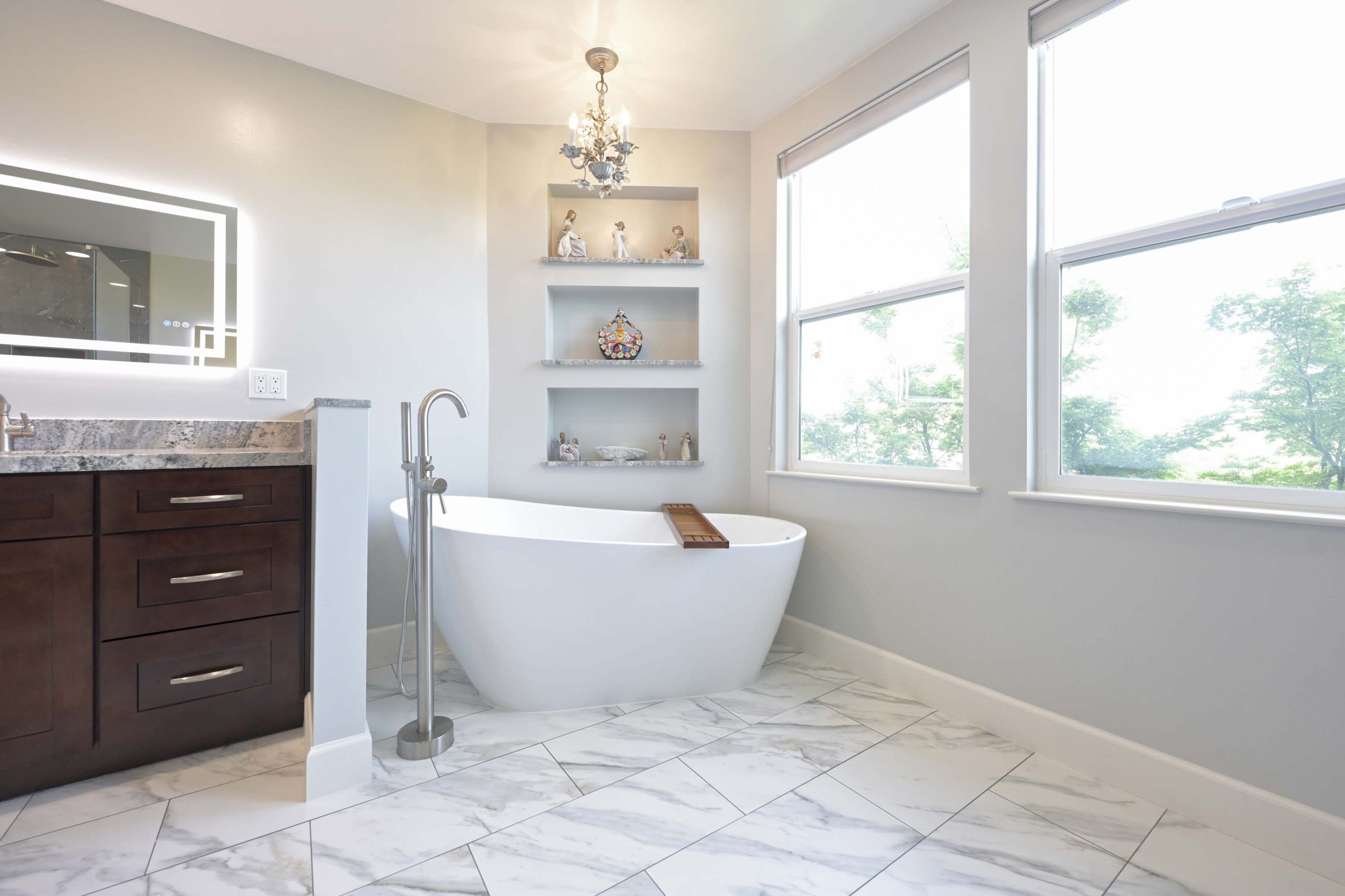 Freestanding tub, built in wall shelves, and large windows in a master bathroom remodel in Rocklin, CA 95765