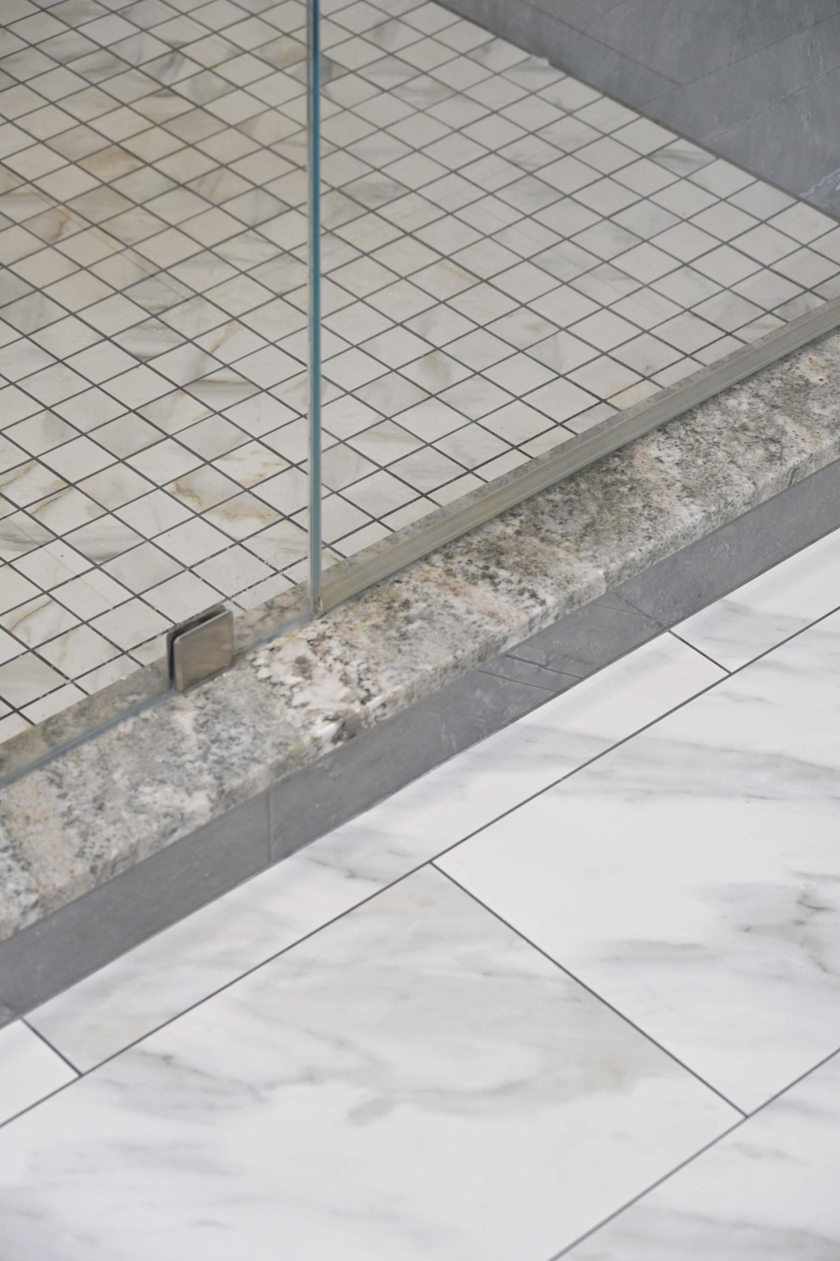 Mosaic shower floor and stone threshold detail in a master bathroom remodel in Rocklin, CA 95765